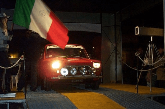 Momento di un evento GU-GU Corse: auto storica, bandiera italiana e passione motoristica